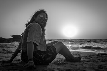 Black and white stylized photo of a happy Carefree Indian Woman Enjoying Beautiful Sunset on the...