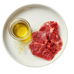 A close up shot of a white dish showcasing fresh uncooked beef sirloin sits elegantly beside a charming little jar of olive oil creating a striking image against a pristine transparent background