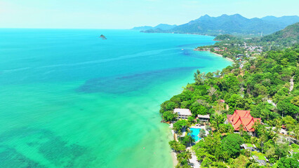 Tropical coastline charms with sandy shores and inviting resorts. Verdant mountains rise, cocooned...