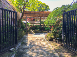 Entrance and stone path into a well manicured japanese garden in Tokyo, Japan