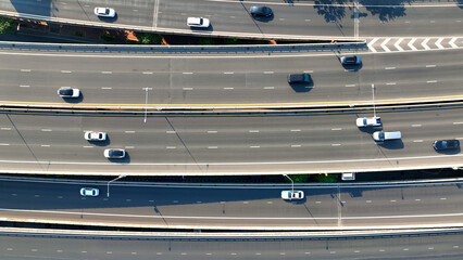 Aerial view, High above, a drone gracefully glides over a bustling highway, capturing the endless...