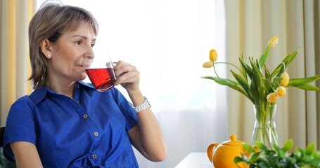 Indoor procrastination, woman on phone with tea. Captivating shot of procrastination, leisurely...