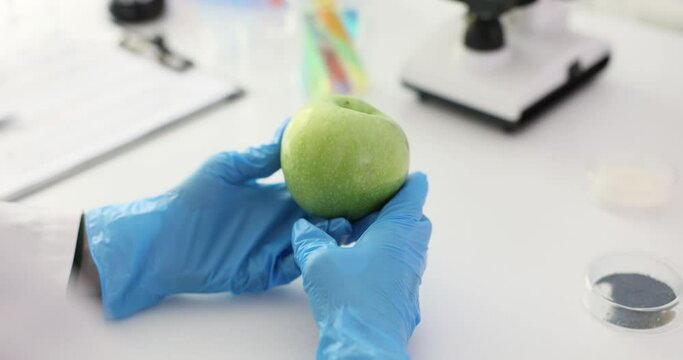 Scientist studying green apple in laboratory