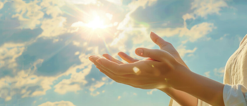 opened both hands fingers of a woman applying reiki healing against the background of a bright sun blue sky and clouds