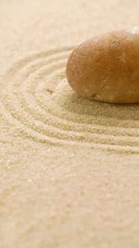 Vertical of making zen garden with sand and stone using mini bamboo wooden rake