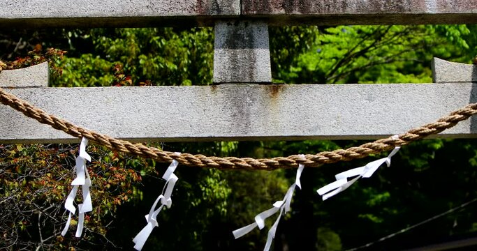 鳥居に張られたしめ縄と風に揺れる紙垂