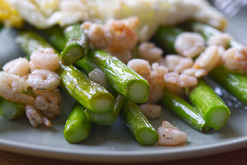 Close-up of green asparagus with shrimps and fried eggs, macro.