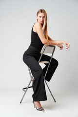 Young Woman Sitting on Chair Posing for Picture