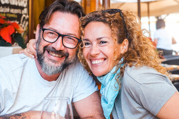 Portrait of happy adult couple posing for a picture sitting at the table restaurant in outdoor....