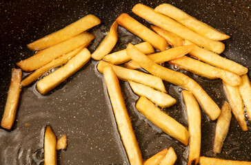 French fries are fried in oil in a frying pan