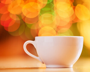 Bokeh, background and coffee cup for warm drink, fine china or porcelain with crockery, catering and kitchenware. Color, light and ceramic drinkware with breakfast or break time beverage at cafe