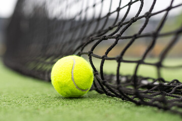 Tennis Ball on the Court against the Court Net
