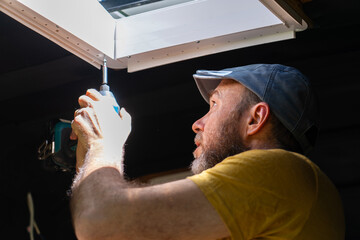 Caucasian man fixing a skylight of a camper van