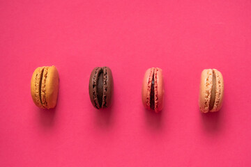 Tasty macaroons on pink background. View from above.