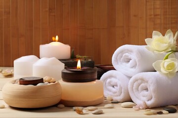 Obraz na płótnie Canvas Beautiful spa composition by towel, candle and flowers with beauty products