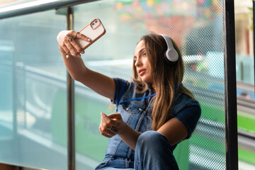 Modern young girl with headphones taking a selfie