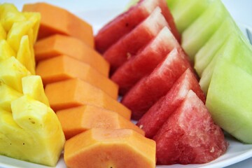 Fresh cut fruits on big bowl. Watermelon, muskmelon and papaya cuts. For buffet menu. on plate with...