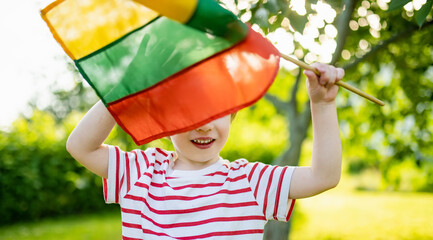 Cute boy holding tricolor Lithuanian flag on Lithuanian Statehood Day, Vilnius, Lithuania