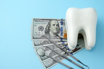 Dollar money bills and tooth model on a bluebackgound with copy space - 794897018