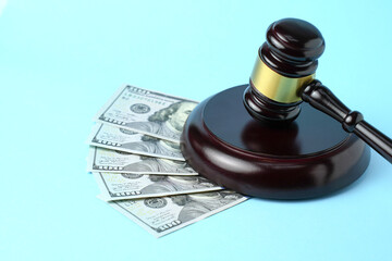 White tooth model with money and judge gavel on blue background with copy space