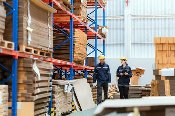 Young employee checking stock In a large cardboard factory