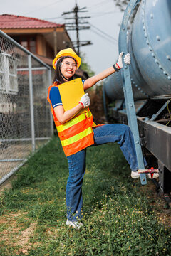 portrait train locomotive engineer women worker. Happy Asian young teen smiling work at train station train track locomotive service maintenance.