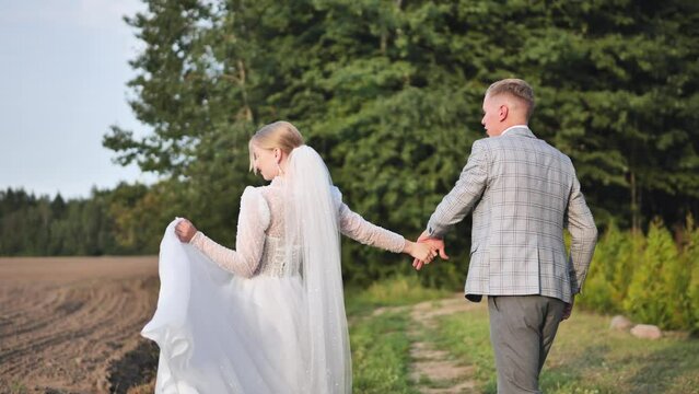 The groom circles the bride walking in nature.