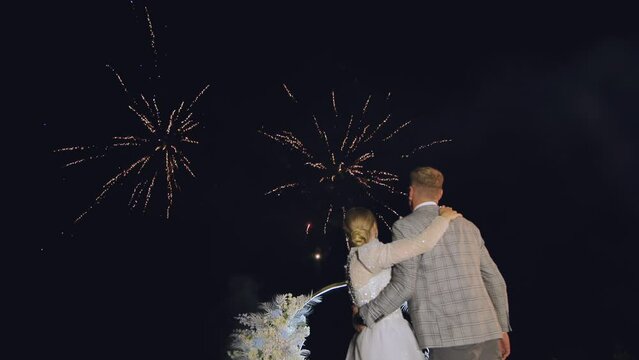 The happy bride and groom in front of the fireworks.