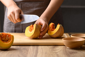 Obraz na płótnie Canvas Organic pumpkin cutting on wooden board, Homemade cooking, Food ingredient