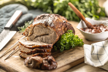 Juicy whole roasted pork neck on a cutting board