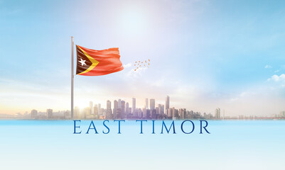 East Timor national flag waving in beautiful building skyline.