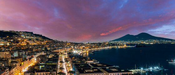 beautiful night panorama of Naples city with nice lights streets flashlights and buildings and volcano Vesuvius with amazing sky on background