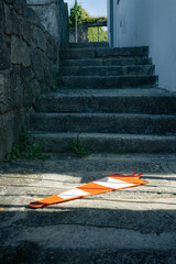 Orange and white cone on stone stairs.