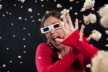 Girl, popcorn and 3d glasses with scream while watching movie, film or horror by dark background....