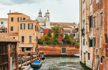 Narrow channel in Venice - boats and old houses