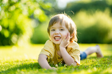 Adorable little boy having fun outdoors on sunny summer day. Kid running outdoors. Child exploring nature. Summer activities for small kids. - 794961854