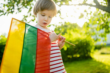 Cute boy holding tricolor Lithuanian flag on Lithuanian Statehood Day, Vilnius, Lithuania - 794963442