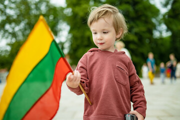 Cute boy holding tricolor Lithuanian flag on Lithuanian Statehood Day, Vilnius, Lithuania - 794970641