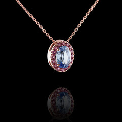 Beautiful red gold pendant with diamonds and sapphire, chain on a black background - obrazy, fototapety, plakaty