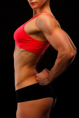 Female fitness bodybuilder posing against black background - 794976216