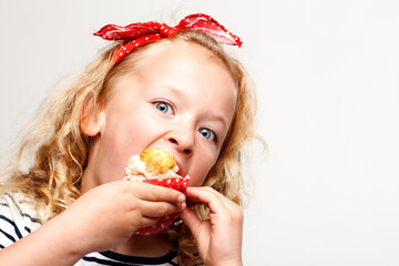 Eating, cupcake and portrait of child in studio for dessert, sweet treat or sugar snack with white...