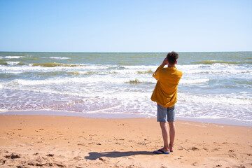 A young attractive man is photographed by the sea.