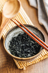 Dried wakame seaweed in bowl on wooden table. - 794991816