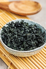 Dried wakame seaweed in bowl on kitchen table.