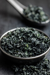 Dried wakame seaweed in bowl on black table. - 794993618