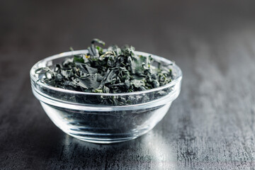 Dried wakame seaweed in bowl on black table. - 794993692
