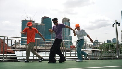 Group of skilled break dancer perform hip hop foot step together at rooftop with city or skyscraper...