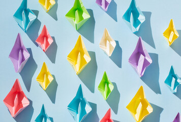 color paper boats on blue background