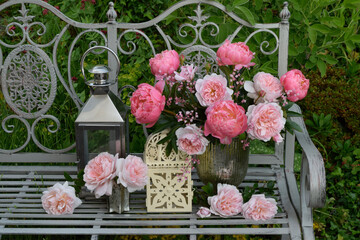 Still life roses and peonies on an ornate  metal bench