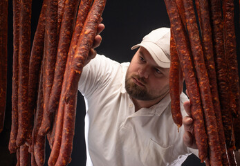  Butcher among the sausages in the drying rack